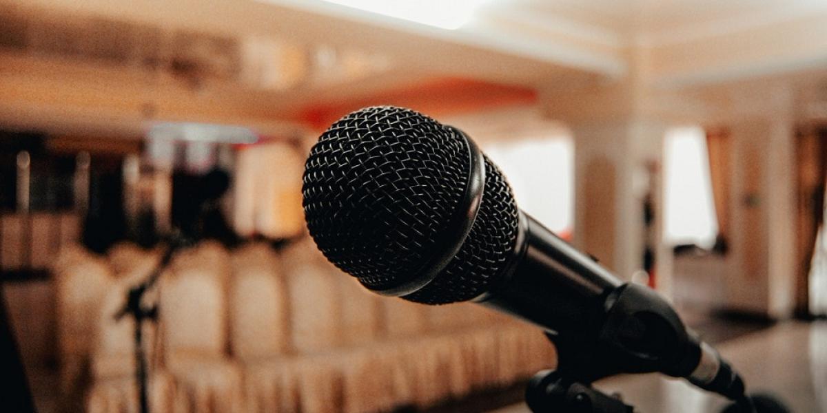 Photo of a microphone, lecture hall on a background.