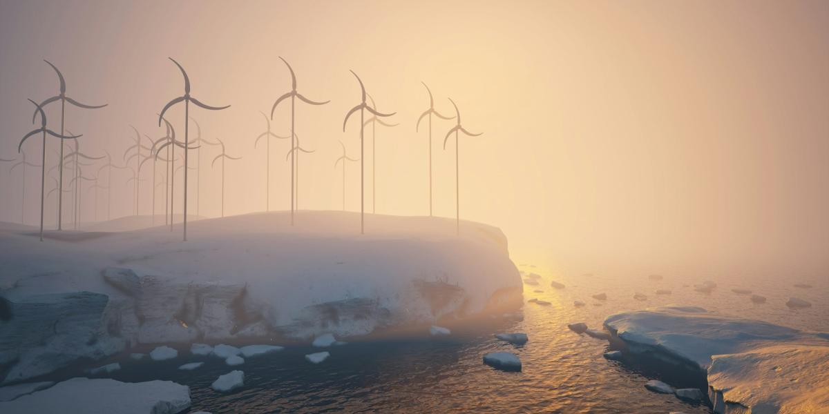 A group of windmills on a snowy hill next to a body of water 