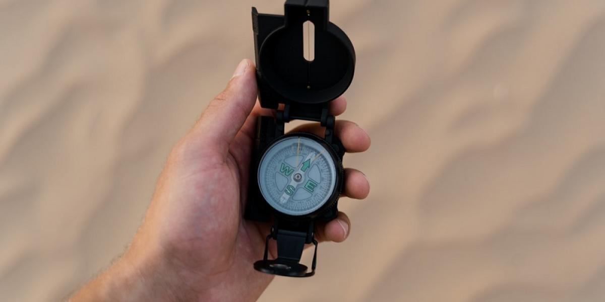 Image of a hand holding a compass.