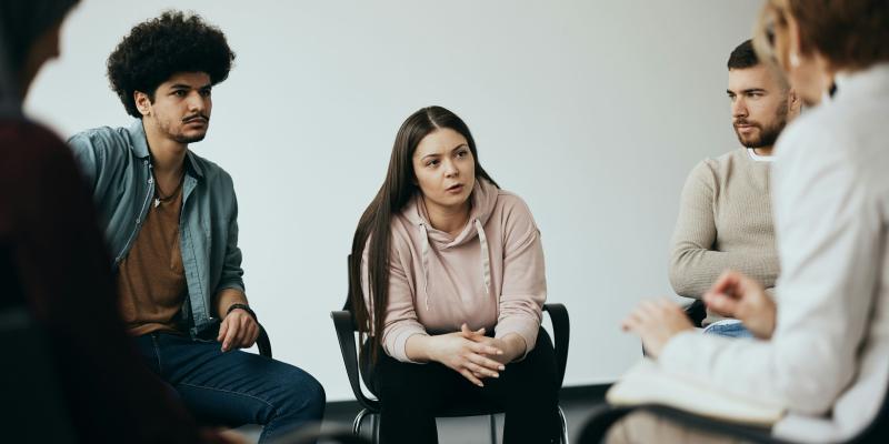 Ryhmä ihmisiä käy dialogia ringissä. 